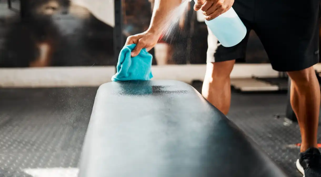 A higiene na academia pode ser feita com álcool ou desinfetante em spray e ajuda a evitar a transmissão de vírus, bactérias e fungos PeopleImages/GettyImages